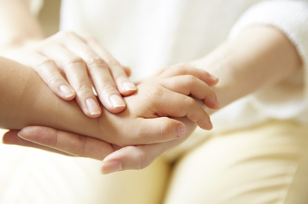 赤ちゃんに保湿剤を塗るママ