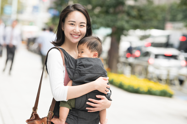 抱っこ紐を使って赤ちゃんを抱っこするママ