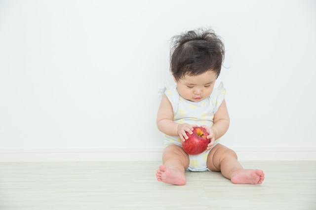 リンゴを触る赤ちゃん